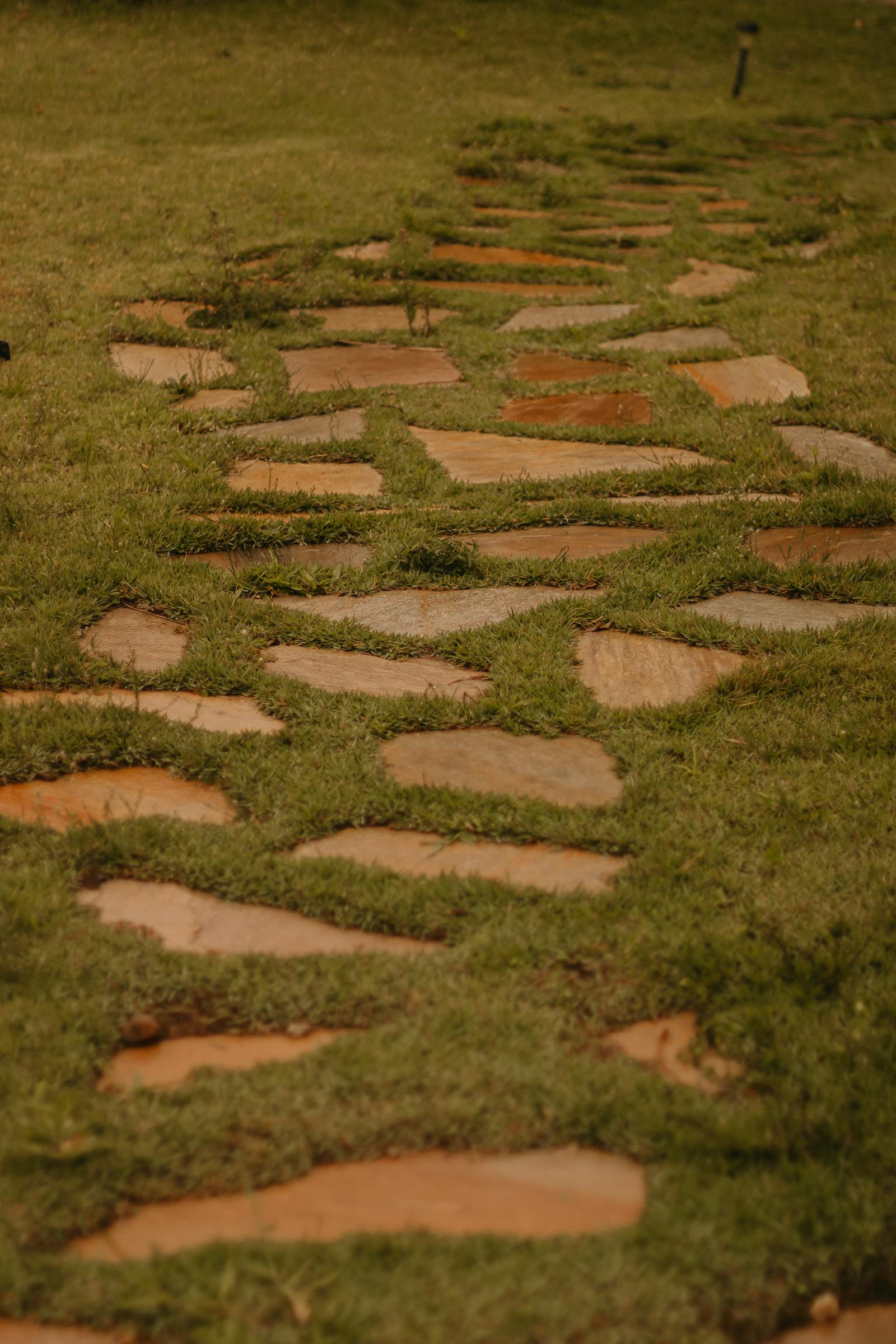 Limestone stepping stones set flush in a Bermuda lawn between a patio and a side gate.